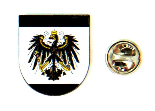 Wappen mit schwarzem Adler und goldener Krone sowie daneben eine runde Abzeichenplakette mit Symbolen.