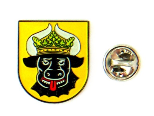 Wappen mit schwarzem Königskopf und Krone auf gelbem Schild, daneben silbernes rundes Abzeichen.